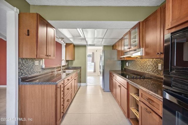 kitchen with light tile patterned floors, appliances with stainless steel finishes, sink, and decorative backsplash