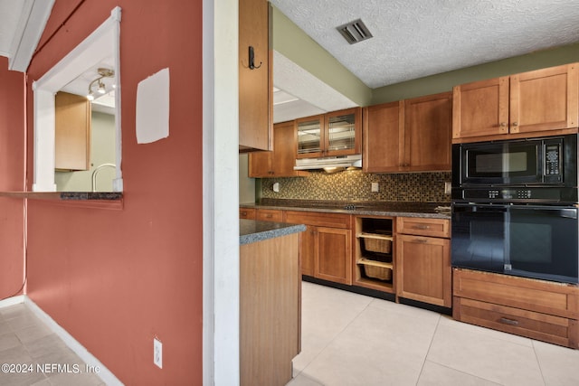 kitchen with black appliances, a textured ceiling, light tile patterned floors, and backsplash