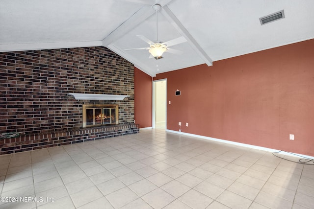 unfurnished living room with a fireplace, lofted ceiling with beams, ceiling fan, and light tile patterned flooring