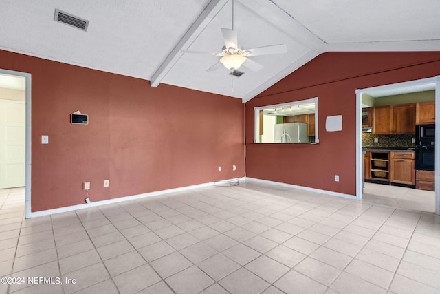 unfurnished living room with vaulted ceiling with beams, ceiling fan, light tile patterned floors, and a textured ceiling