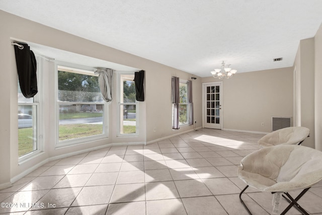 interior space featuring a chandelier, a textured ceiling, and light tile patterned floors