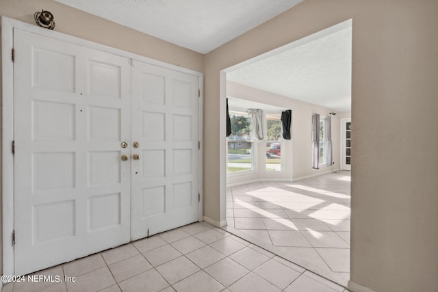 tiled foyer with a textured ceiling