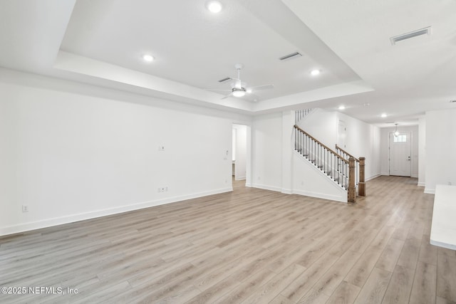 211 Rushing Dr, Saint Augustine, FL 32092 - unfurnished living room featuring a tray ceiling, stairway, light wood-type flooring, recessed lighting, and ceiling fan