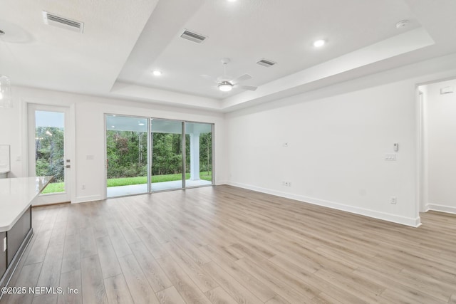 211 Rushing Dr, Saint Augustine, FL 32092 - unfurnished living room featuring a raised ceiling, light wood-type flooring, a ceiling fan, and recessed lighting