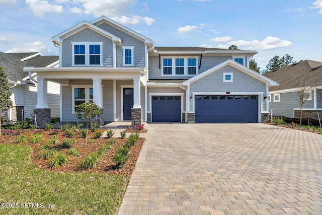 211 Rushing Dr, Saint Augustine, FL 32092 - craftsman house featuring covered porch, decorative driveway, stone siding, and a garage