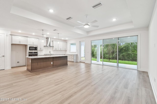 211 Rushing Dr, Saint Augustine, FL 32092 - kitchen featuring wall chimney exhaust hood, a tray ceiling, built in microwave, light countertops, and recessed lighting