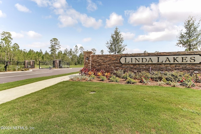 community / neighborhood sign featuring a yard