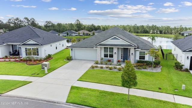 view of front of home featuring a water view, a front lawn, and a garage