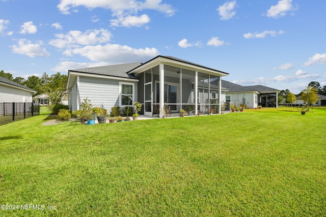 rear view of property with a yard and a sunroom