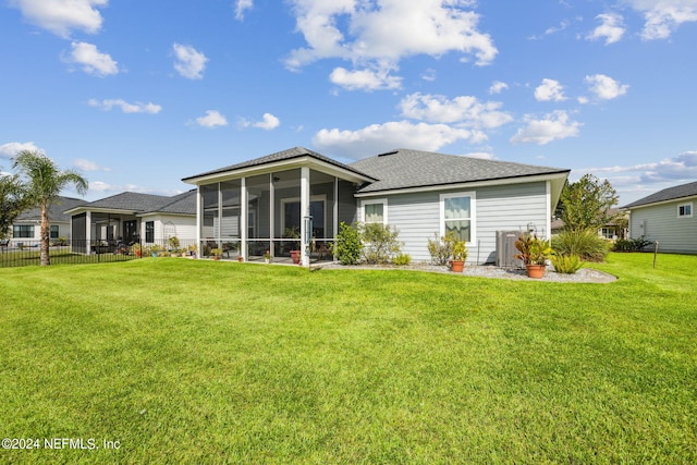 back of house with a sunroom and a yard