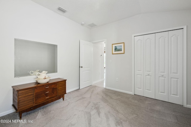 carpeted bedroom featuring a closet and vaulted ceiling