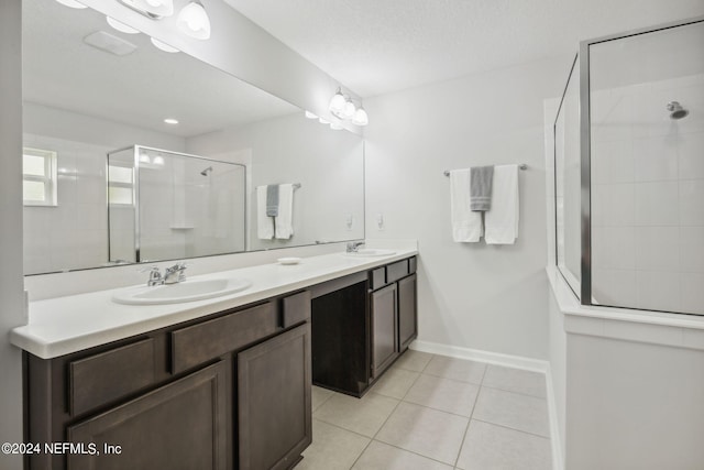 bathroom with tile patterned floors, a shower with door, a textured ceiling, and vanity