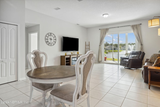 dining space featuring a textured ceiling and light tile patterned floors