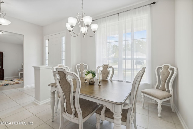 tiled dining room with an inviting chandelier