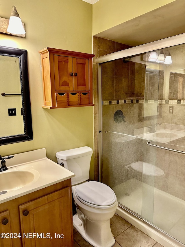 bathroom featuring a stall shower, vanity, toilet, and tile patterned floors