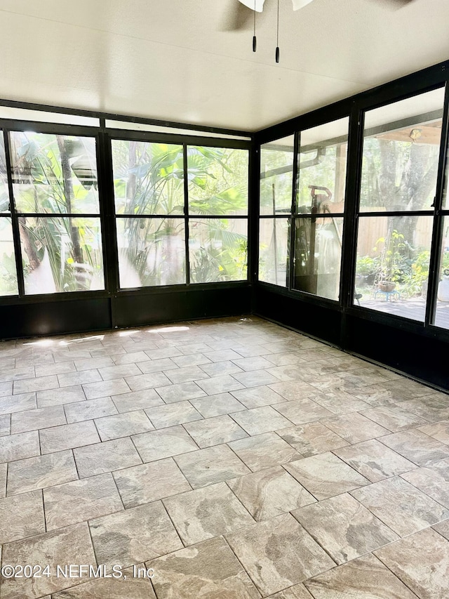 unfurnished sunroom with a ceiling fan