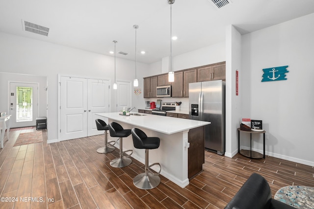 kitchen featuring stainless steel appliances, wood finish floors, a sink, and visible vents