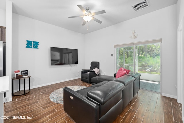 living area featuring baseboards, visible vents, a ceiling fan, and wood finish floors