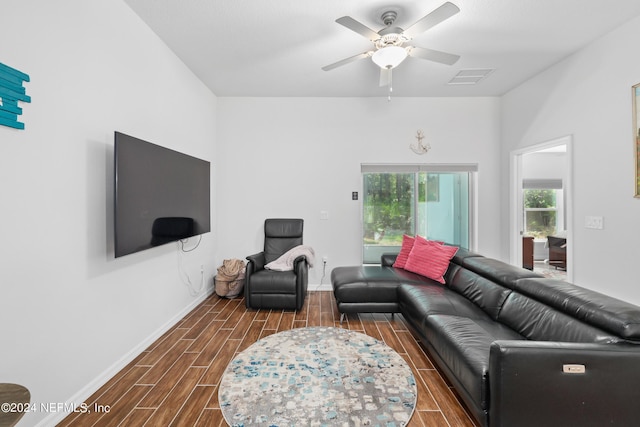 living area featuring wood finish floors, visible vents, ceiling fan, and baseboards