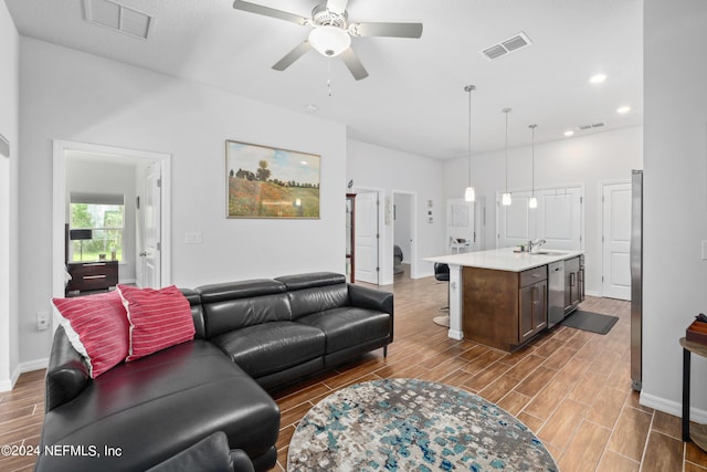 living area with wood tiled floor, visible vents, and a ceiling fan