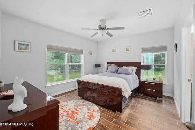 bedroom featuring wood tiled floor, visible vents, ceiling fan, and baseboards