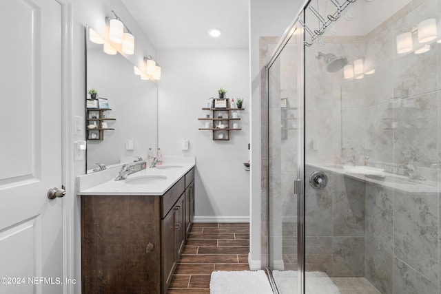 full bathroom featuring wood finish floors, a sink, a shower stall, and double vanity