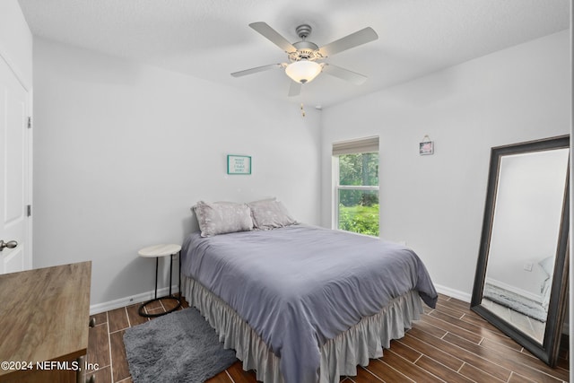 bedroom with wood finish floors, a ceiling fan, and baseboards