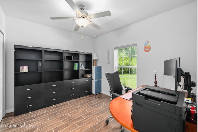 office area with wood finish floors, a ceiling fan, and baseboards