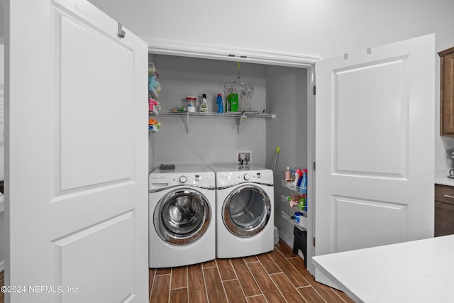 laundry area featuring wood tiled floor, laundry area, and independent washer and dryer