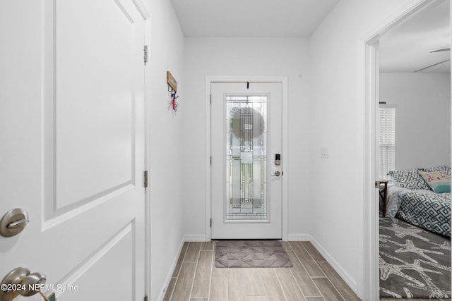 foyer featuring wood tiled floor and baseboards