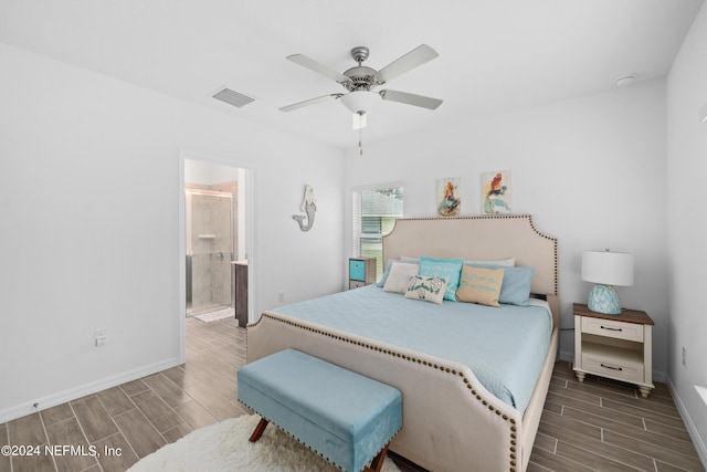 bedroom featuring ceiling fan, visible vents, baseboards, wood tiled floor, and ensuite bath