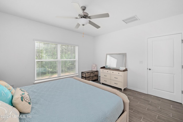 bedroom featuring ceiling fan, wood finish floors, visible vents, and baseboards