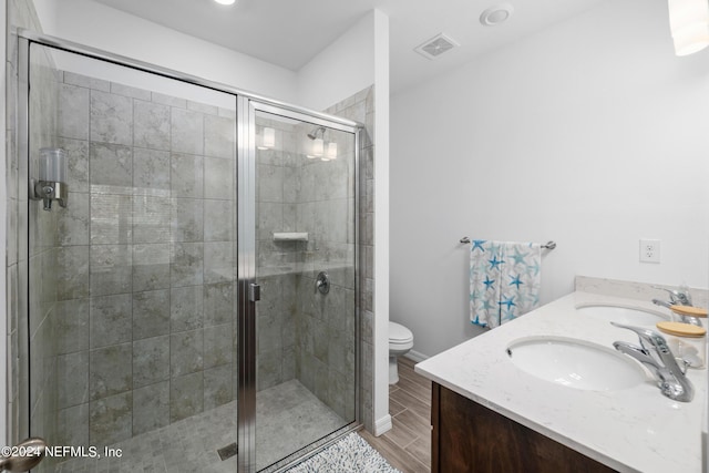 bathroom featuring double vanity, a stall shower, visible vents, and a sink