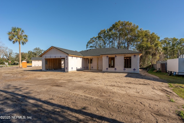 unfinished property with a garage and fence