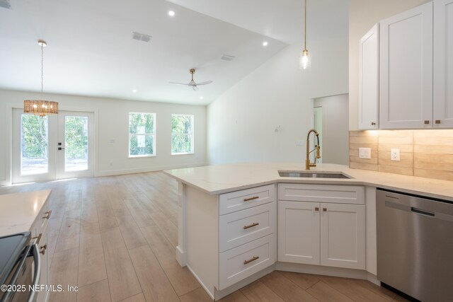 411 Royal Rd, Saint Augustine South, FL 32086 - kitchen featuring appliances with stainless steel finishes, a peninsula, white cabinetry, light wood finished floors, and backsplash