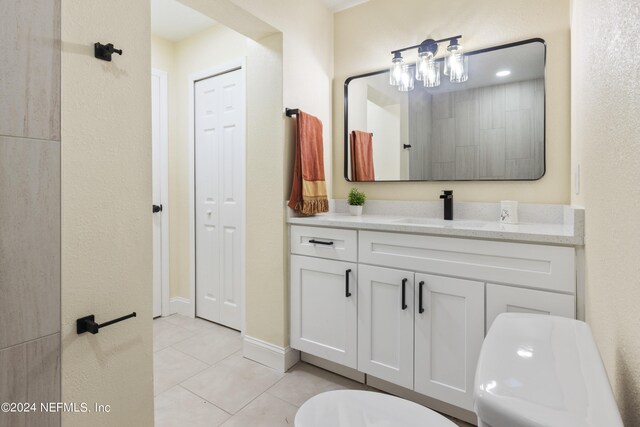 bathroom with vanity, toilet, and tile patterned flooring