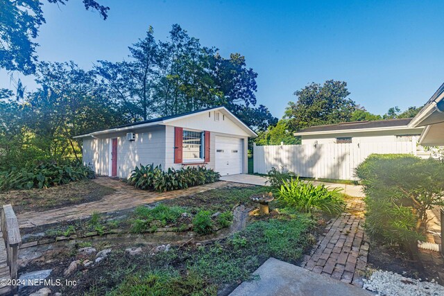 ranch-style house featuring a garage and an outbuilding