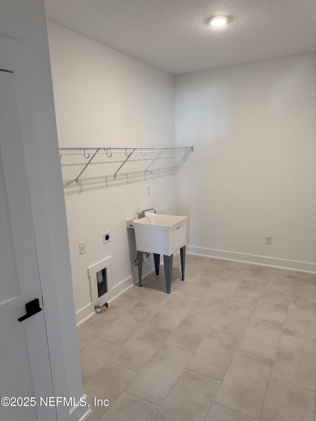 washroom with electric dryer hookup and a textured ceiling