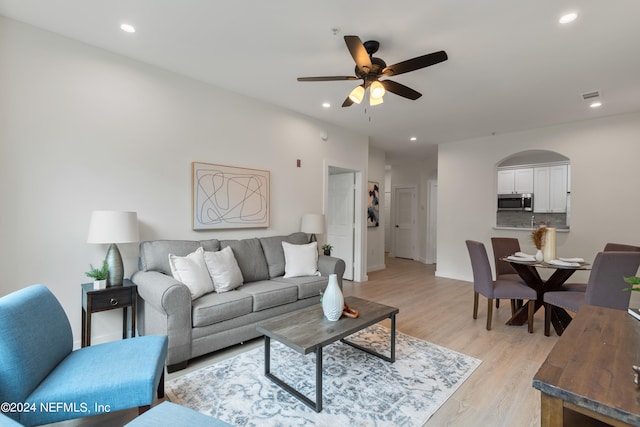 living room featuring light hardwood / wood-style flooring and ceiling fan