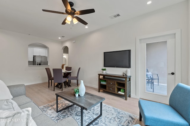 living room featuring light hardwood / wood-style flooring and ceiling fan