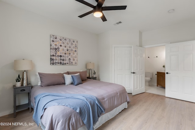 bedroom with light wood-type flooring, ceiling fan, and ensuite bathroom