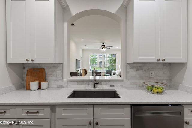 kitchen with white cabinets, backsplash, light stone countertops, ceiling fan, and sink