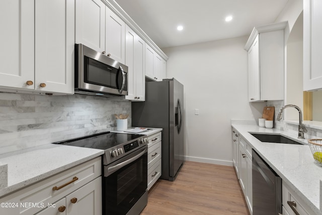 kitchen with light stone countertops, white cabinetry, and appliances with stainless steel finishes