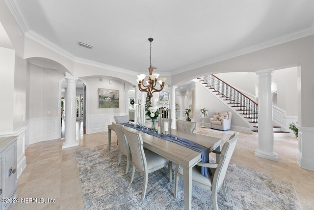 dining area featuring ornamental molding, an inviting chandelier, and ornate columns