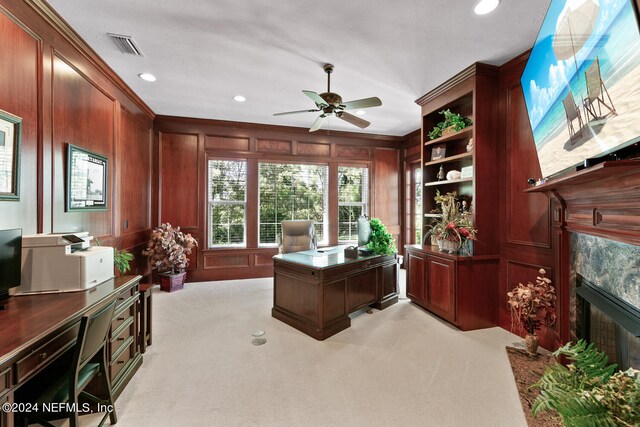 office area featuring a fireplace, light colored carpet, ornamental molding, and ceiling fan