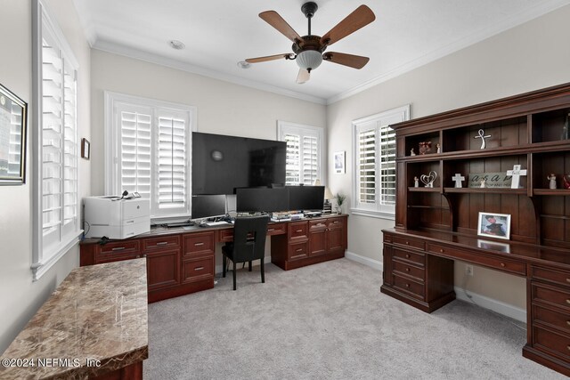 office area featuring light colored carpet, ceiling fan, ornamental molding, and built in desk