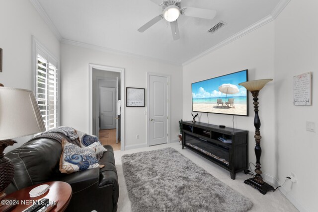 carpeted living room featuring ornamental molding and ceiling fan