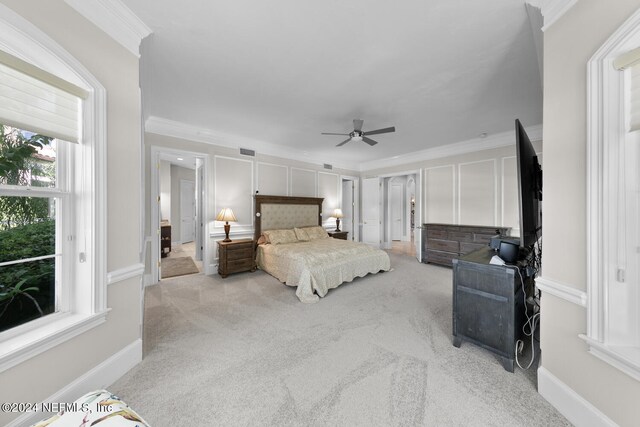 carpeted bedroom featuring ceiling fan and crown molding