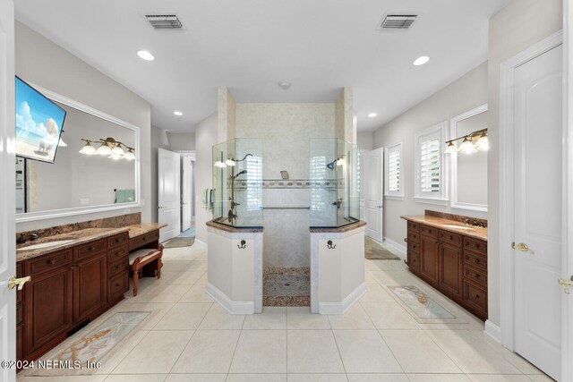 bathroom featuring tiled shower, vanity, and tile patterned flooring