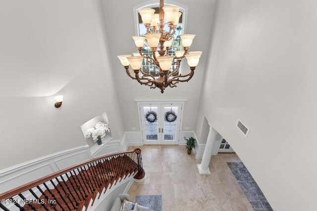 entrance foyer featuring french doors and a chandelier